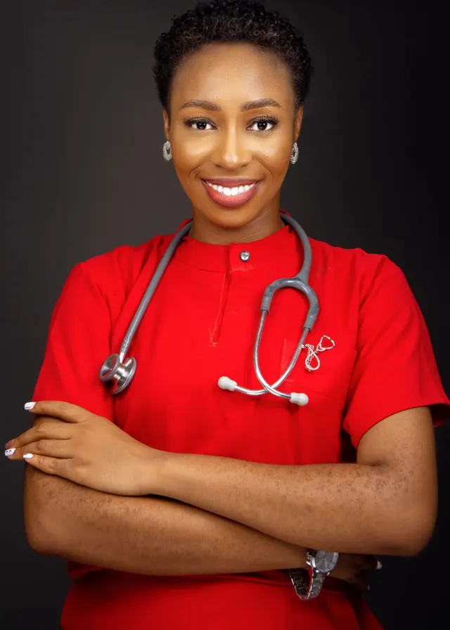 A smiling clinician in red scrubs with a stethoscope